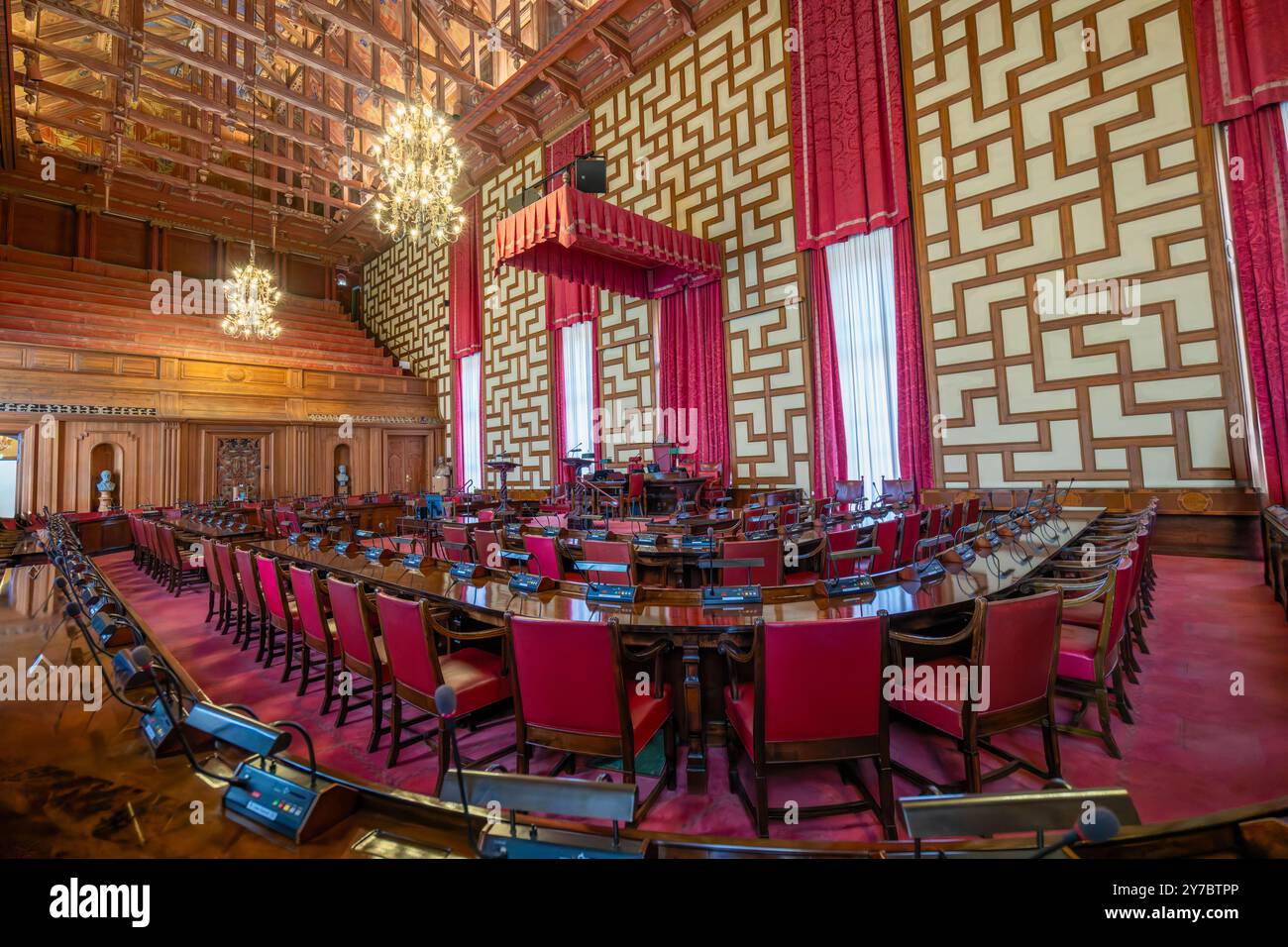 Stockholm, Schweden - 9. Mai 2024: Die opulente Versammlungshalle des Stockholmer Rathauses. Komplizierte Holzschnitzereien, satte rote Samtvorhänge und ein großer ch Stockfoto
