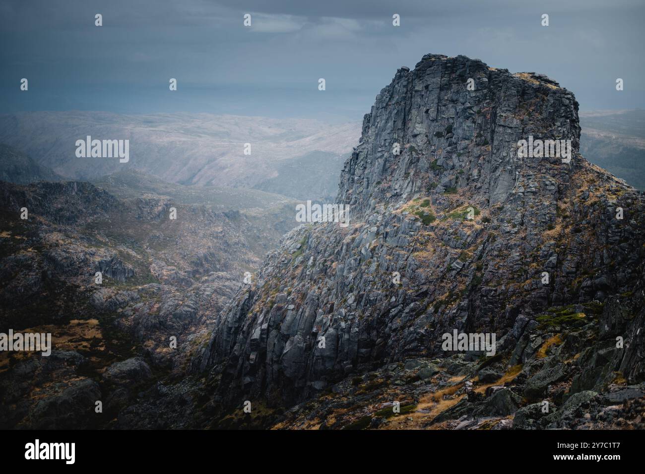 Die zerklüfteten, malerischen Berge von Serra da Estrela stehen hoch unter bewölktem Himmel, ihre felsigen Gipfel schaffen eine dramatische Szene im wolkigen Wetter Stockfoto