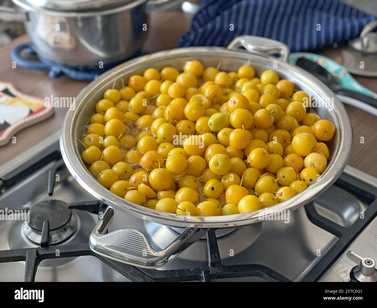 Kleine gelbe Äpfel im Topf auf dem Gasherd. Geschmackvolles Dessert, Marmelade, Vorbereitungen für den Winter. Im Garten geerntet. Ökologisches Produkt. Stockfoto
