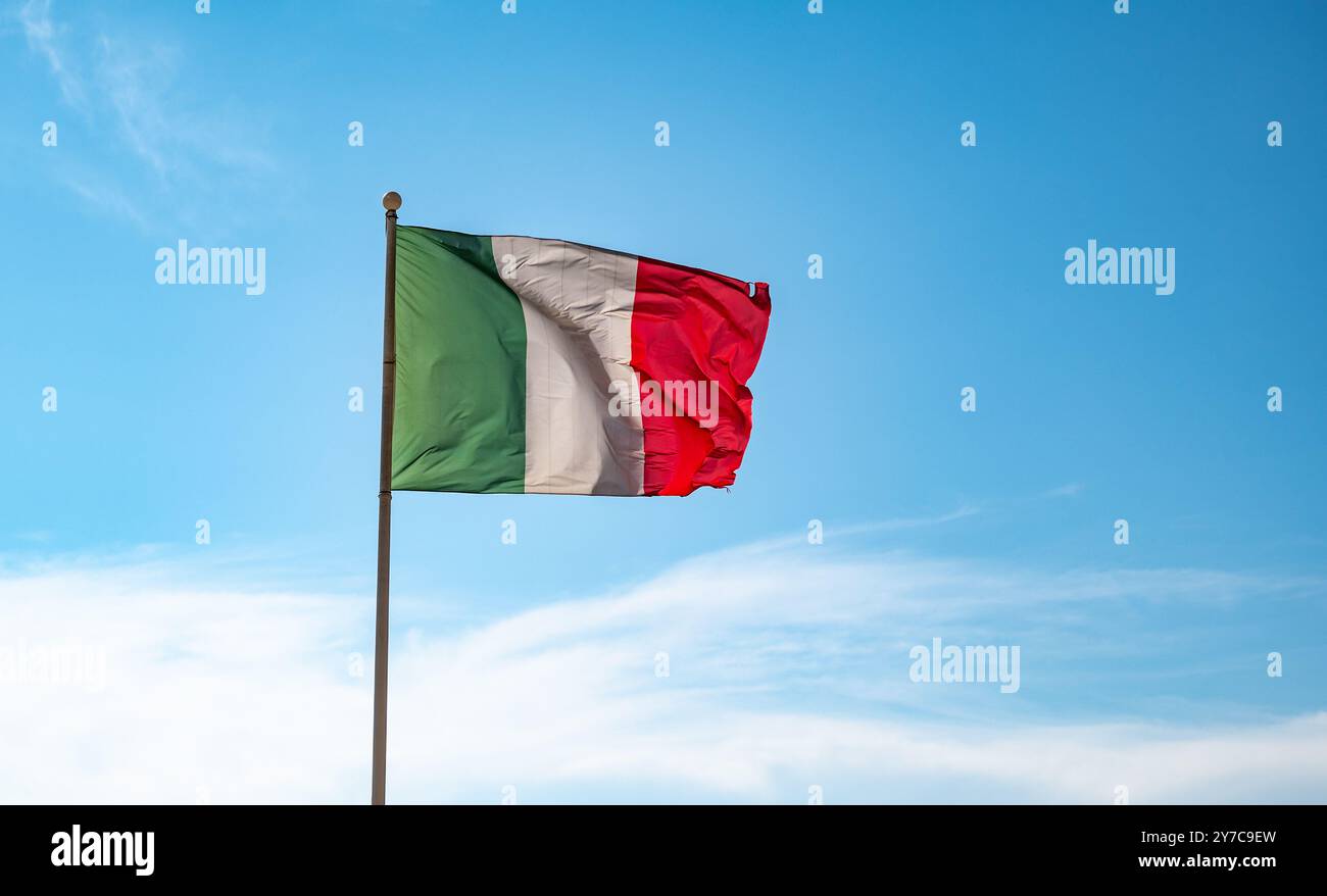 Italienische Flagge winkt auf blauem Himmel Hintergrund. Stockfoto
