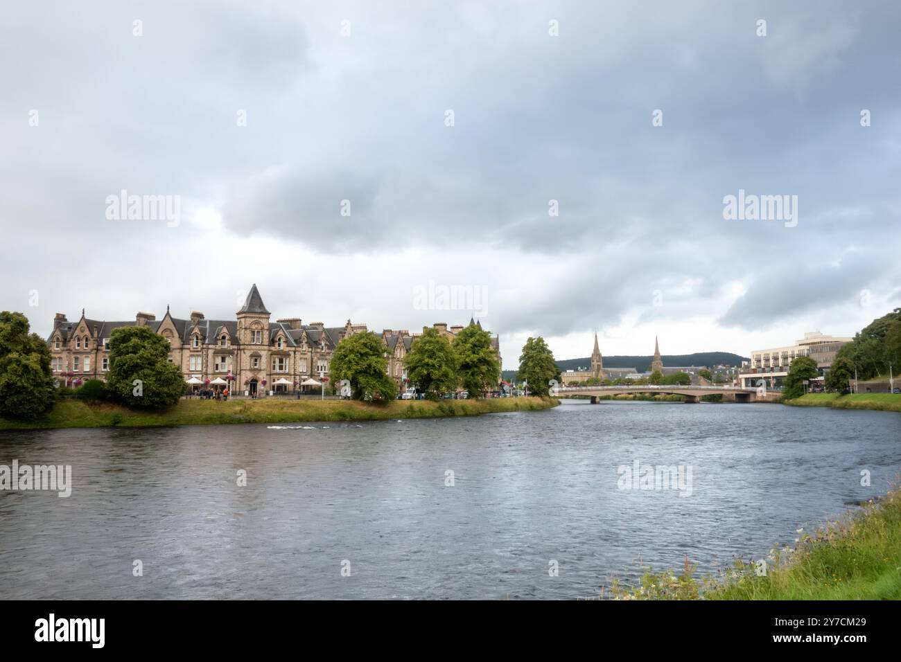 Blick auf den Fluss Ness, der durch die mittelalterliche Stadt Inverness, Schottland, fließt an einem bewölkten Sommertag Stockfoto