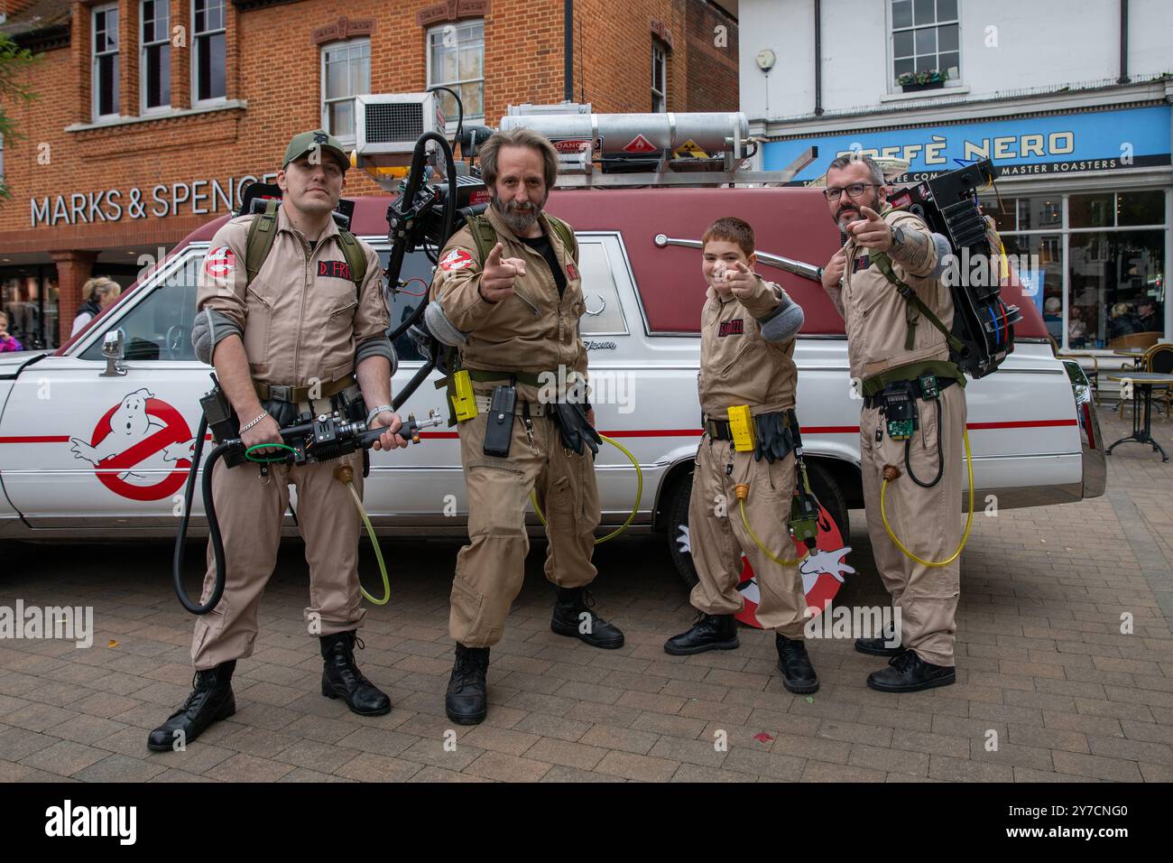 Ghostbuster-Imitatoren posieren für Fotos. Klassiker und Nachbildungen berühmter Autos aus Film und Fernsehen stehen im Epsom Town Centre für Fotogelegenheiten für Familien und Touristen an. Stockfoto