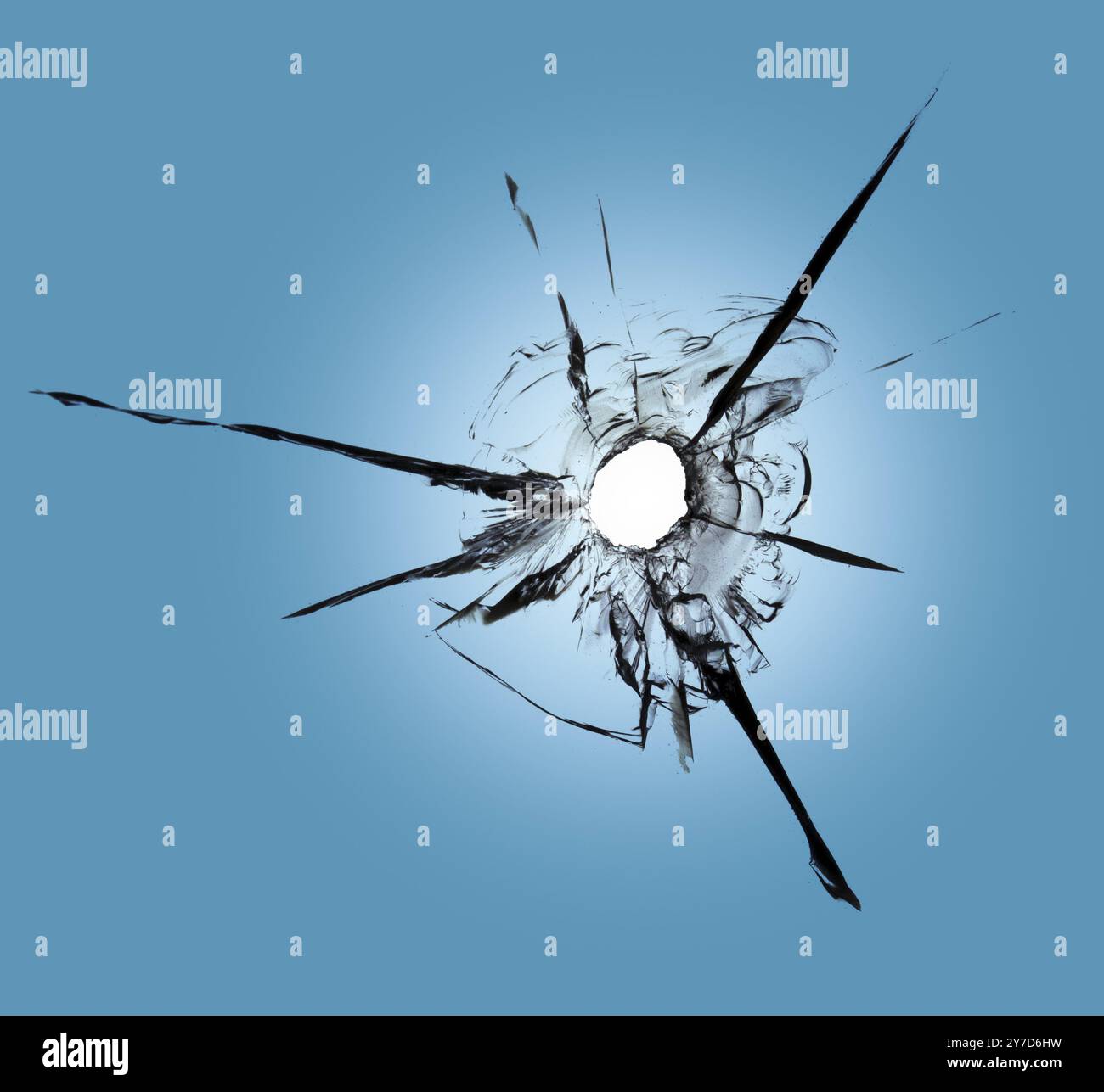 Einschusslöcher im Fenster gegen den blauen Himmel. Folgen von Schalen und Rissen am Glas Stockfoto