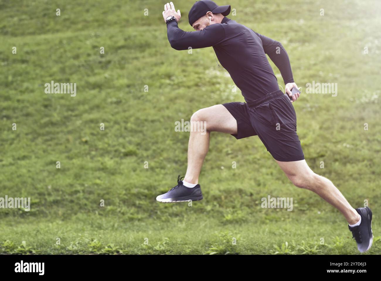 Porträt eines konzentrierten, selbstbewussten, muskulösen Sportlers, der Shorts und Turnschuhe trägt Stockfoto