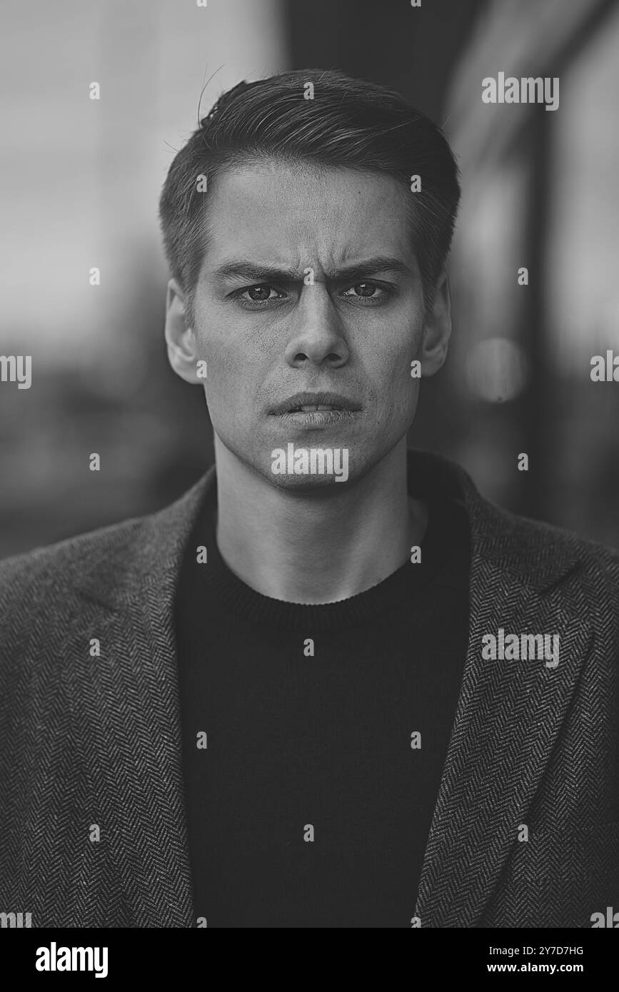 Porträt eines gutaussehenden kaukasischen Mannes, der ernsthaft die Stirn runzelt. Emotionales Gesichtskonzept Stockfoto