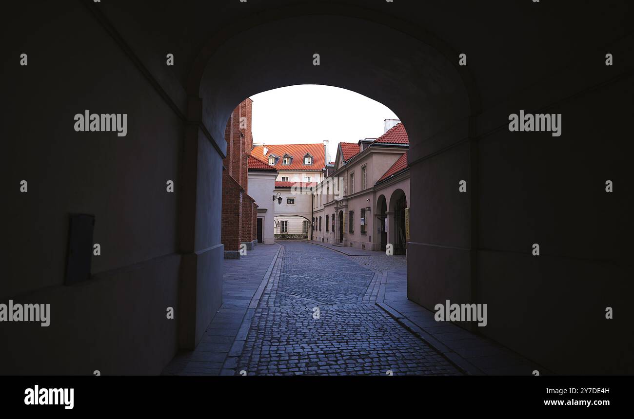 Ruhige Eleganz in Warschau: Torbogen, der historische Bauwerke umrahmt, leere Straßen Stockfoto