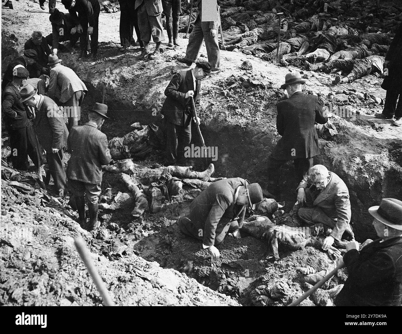 Deutsche Zivilisten exhumieren ein Massengrab mit den Leichen von Gefangenen aus dem Konzentrationslager, die von der SS in einer Scheune vor Gardelegen getötet wurden. Aktionen wie diese waren Teil des Entnazifizierungsprozesses. Dieser Prozess war ein Versuch, die Kultur und Gesellschaft Deutschlands und Österreichs von nationalsozialem Einfluss und Ideologie zu befreien. Ein Teil des Prozesses bestand darin, die Öffentlichkeit mit den Beweisen für die Verbrechen zu konfrontieren, die in ihrem Gebiet begangen wurden. Stockfoto