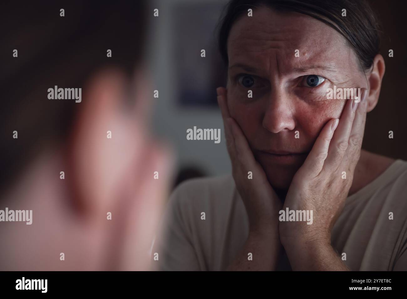 Konzept der psychischen Gesundheit und des psychischen Wohlbefindens, Frau, die ihre Reflexion im Spiegel betrachtet, selektiver Fokus Stockfoto