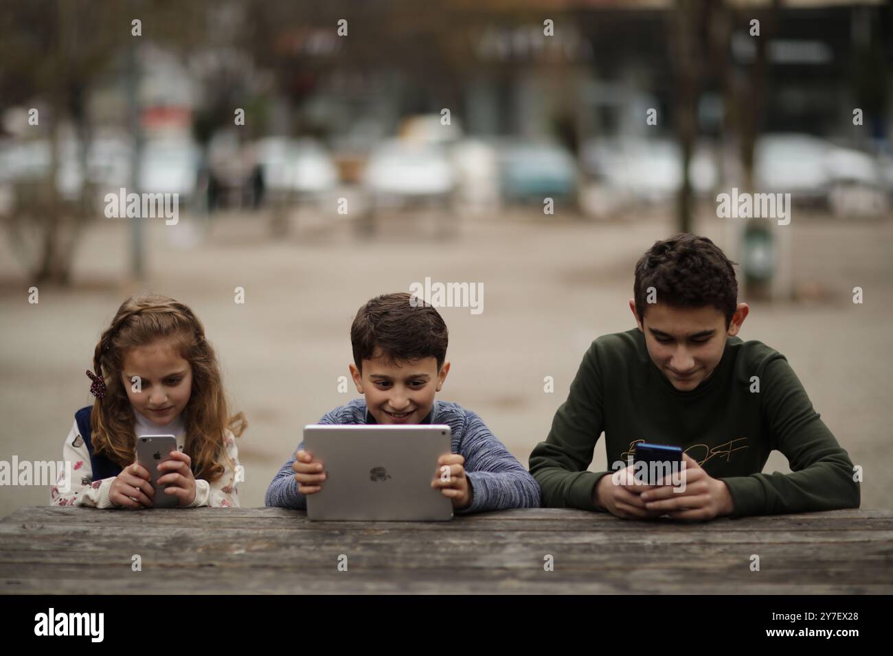 Kinder spielen mit ihrem Smartphone und ipad in ihrem Haus ohne elterliche Aufsicht in der türkischen Stadt Gaziantep. Die Tatsache, dass viele Kinder in jungen Jahren mit Mobiltelefonen und Tablets spielen, hat Probleme in Bezug auf ihre kognitive Entwicklung und ihre Sicherheit vor möglichen Strahlungen und aus dem Internet aufgeworfen. Die weit verbreitete Nutzung von Technologie hat die jüngsten Mitglieder der meisten Gesellschaften getroffen. Smartphones und Tablets haben oft traditionelle Kinderaktivitäten wie Puppen, Brettspiele und Spiele im Freien ersetzt. Kinder werden oft an den Geräten festgeklebt Stockfoto