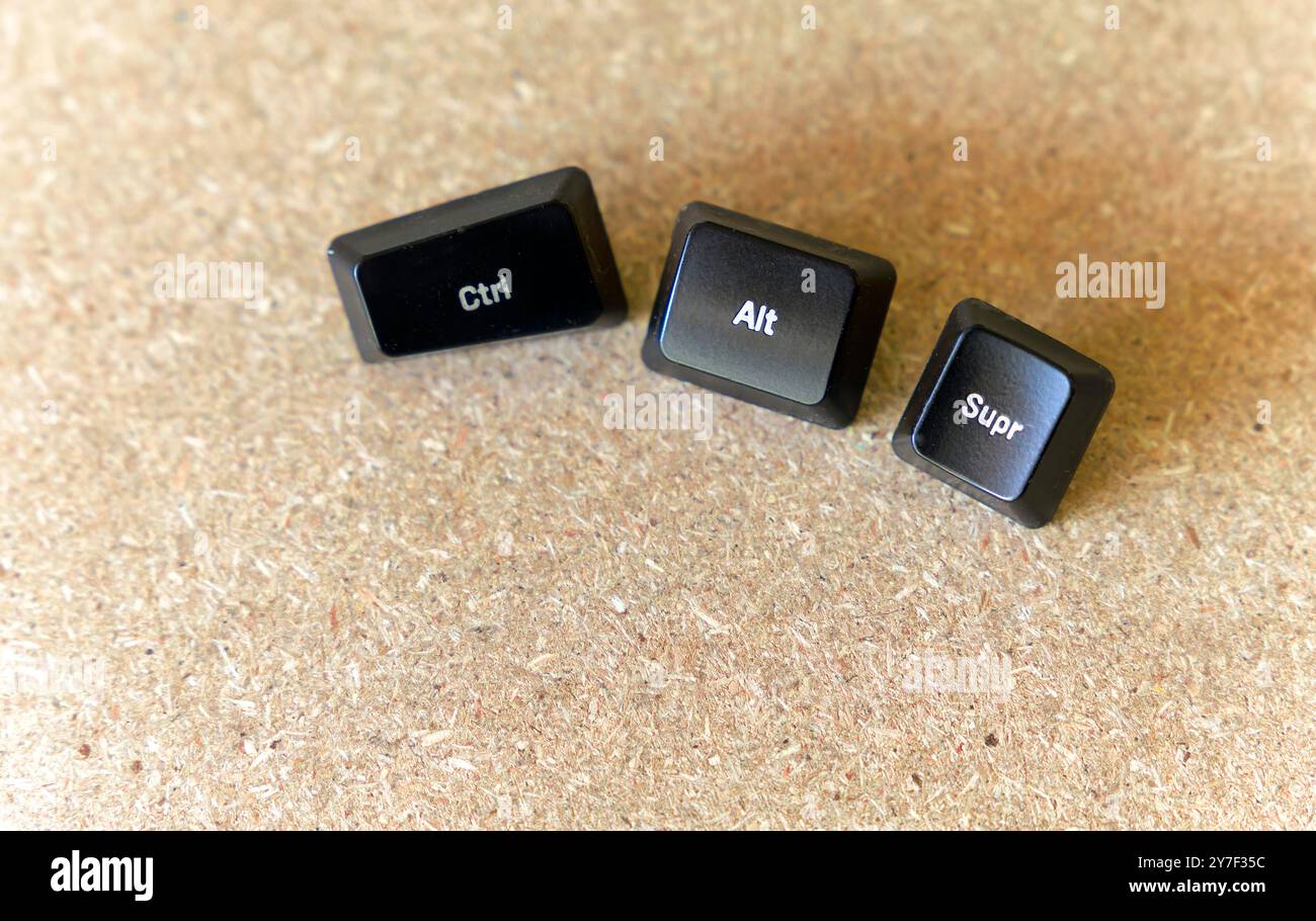 Drei schwarze Schlüssel sind auf einer Holzoberfläche. Die Tasten sind mit den Buchstaben Strg, Alt und Supr. Gekennzeichnet. Konzept des erzwungenen Herunterfahrens Stockfoto