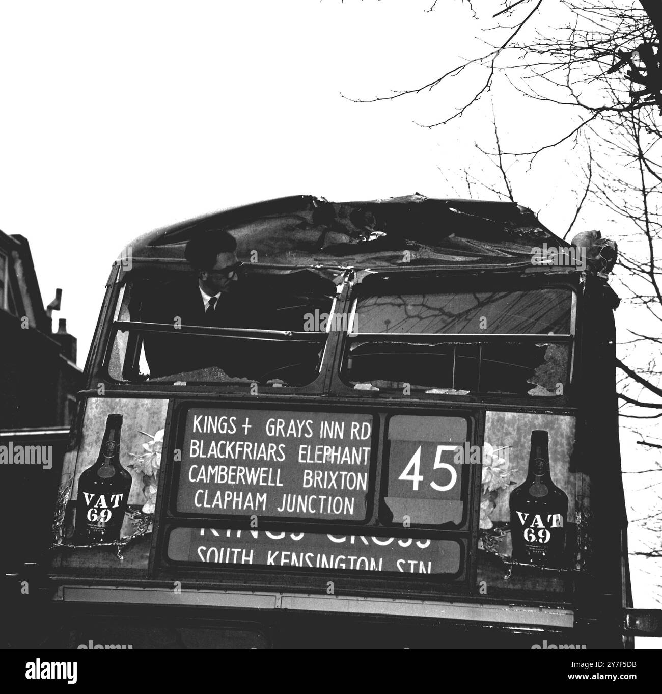 London Bus Crash. Ein London Transport Bus der Linie 45 wurde schwer beschädigt, als er heute in der Grays Inn Road in Holborn mit einem Kran kollidierte. Der Kran wurde aus einer Seitenstraße in die Grays Inn Road gefahren, als der Ausleger das obere vordere Deck des Busses traf. Hier lehnt sich ein Mann hin, um die Verdammung zu untersuchen. April 1962. Stockfoto