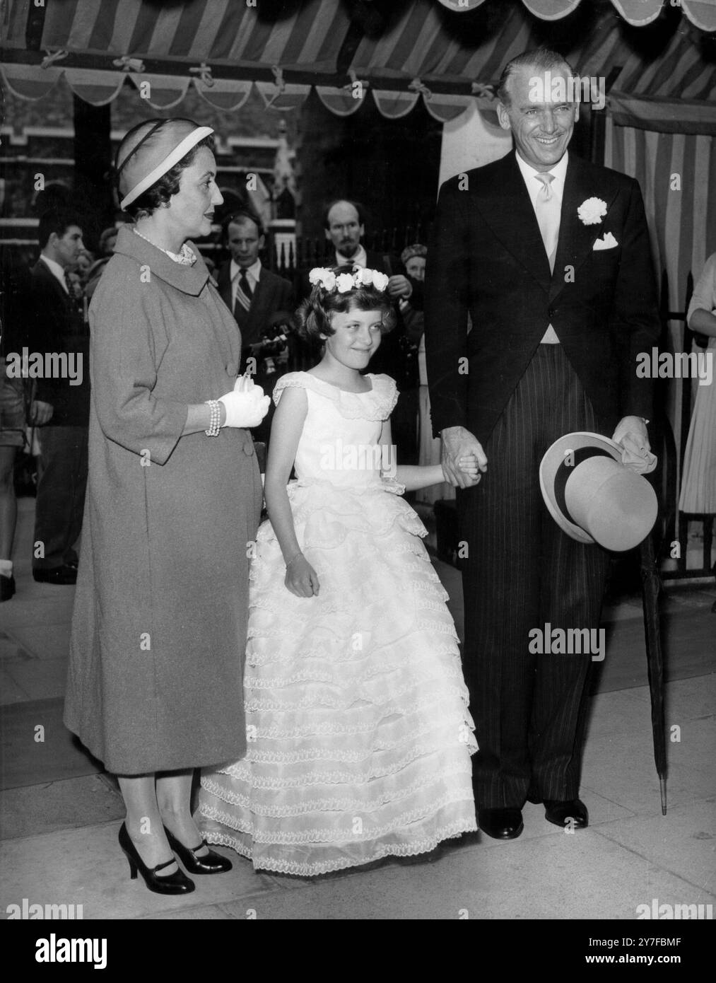 Fairbanks sind Hochzeitsgäste - Gäste bei einer Hochzeit in der St. Margaret's Church, Westminster, London, am 24. Juli 1956 waren Herr Douglas Fairbanks, seine Frau und Tochter Melissa. Verheiratet waren Captain M G C Jeffreys, Grenadier Guards und Miss Sarah Garnett, die 1954 die britische Juniorski-Meisterin war. Stockfoto