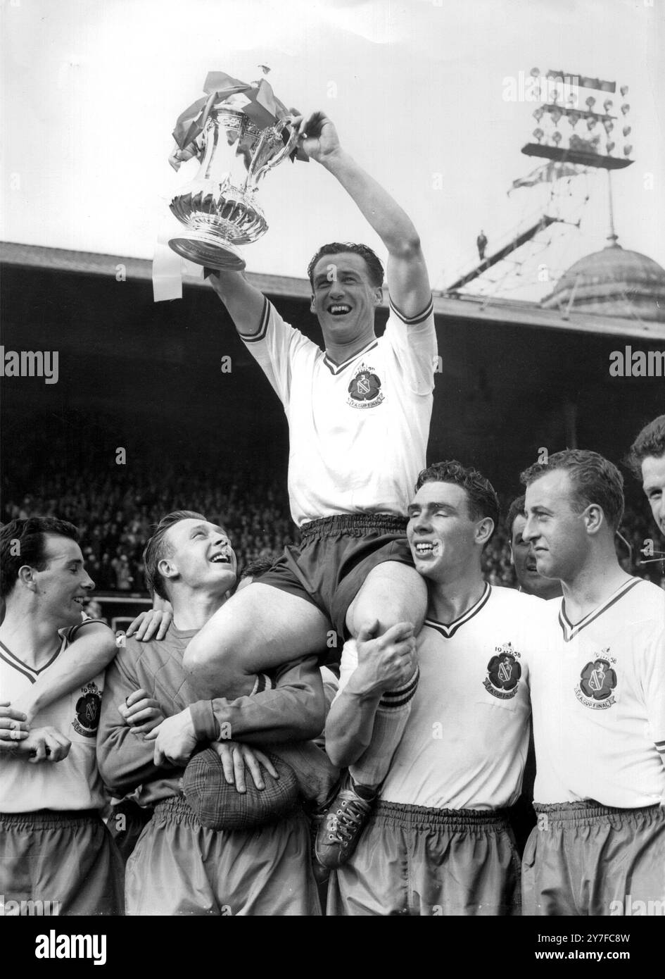 1958 FA Cup Finale Manchester Utd V Bolton Wanderers, der gerade vom Duke of Edinburgh, Nat Lofthouse Mittelstürmer und Kapitän der Bolton Wanderers präsentiert wurde, wird von Teamkollegen geleitet, nachdem Bolton Manchester Utd 2-0 im Cup Finale in Wembley besiegt hatte. Mai 1958. Stockfoto