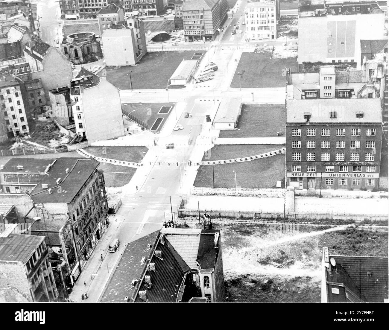 Eine Luftaufnahme des Checkpoint Charlie am Berliner Sektorgrenzübergang Friedrichstraße. Im Hintergrund befinden sich auf beiden Straßenseiten kommunistische Ost-Berliner Kontrollschuppen. Berlin, Deutschland - 14. August 1962 Stockfoto