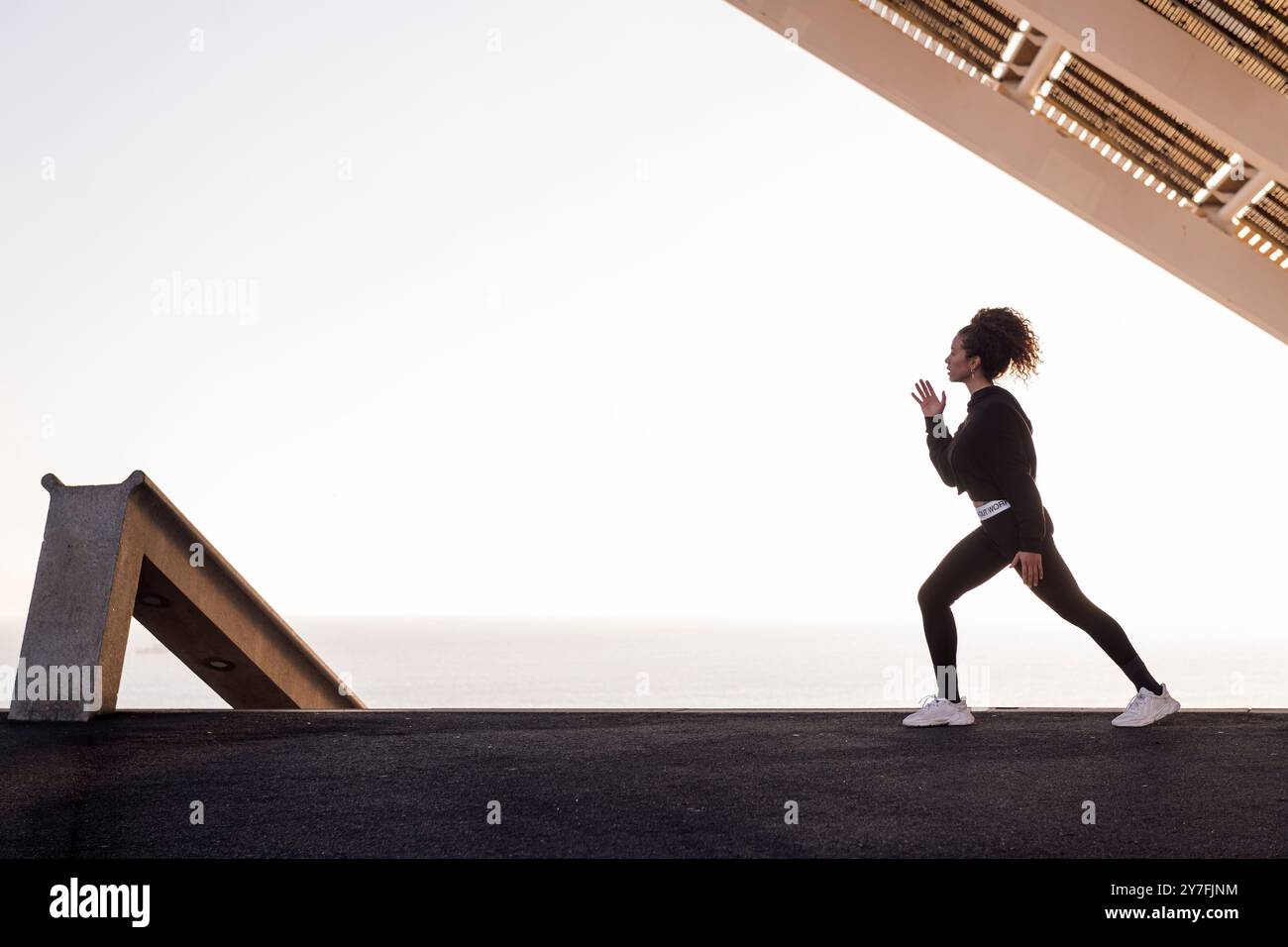 Athlet, der während des Trainings seitlich hockt Stockfoto