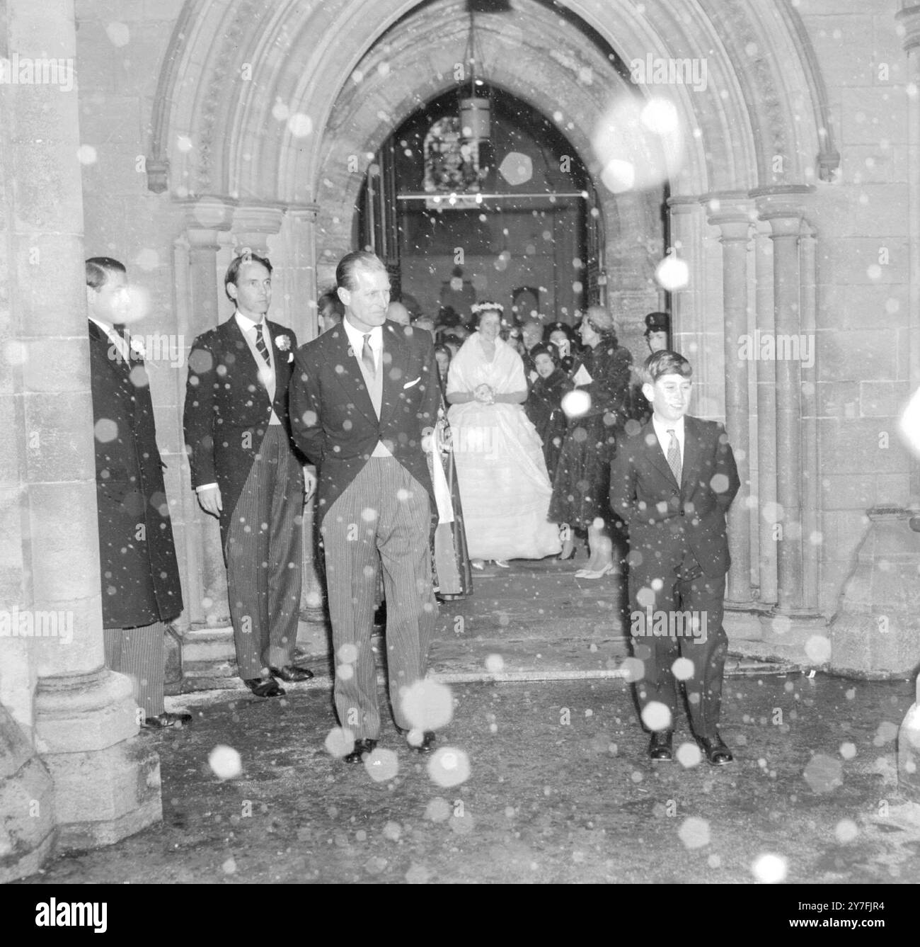Nach der Hochzeit von Lady Pamela Mountbatten und Mr. David Hicks verlässt Romney Abbey und ist Prinz Charles, einer der Gäste. Der Schnee fiel, als die Hochzeitsfeier die Abtei verließ. Januar 1960 Stockfoto