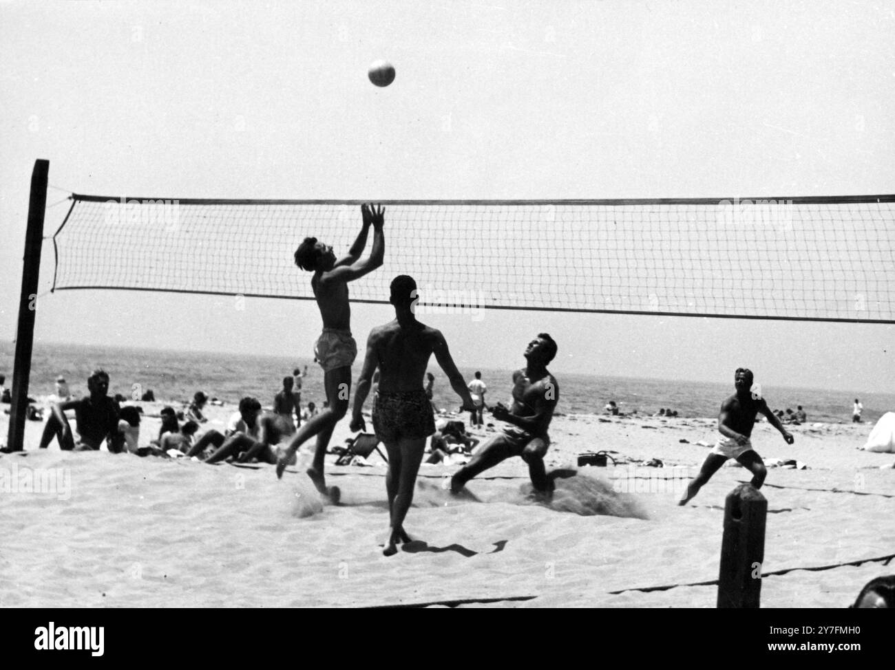 Beachvolleyball am Muscle Beach, Santa Monica, Kalifornien. 1940er Jahre, der Strand war der nächstgelegene Küstenstreifen zu Hollywood und war ein Magnet für Filmliebhaber, die ihr farblich gebräuntes Aussehen zeigen wollten. Santa Monica ist der offizielle Geburtsort des Beachvolleyball, wie es heute gespielt wird, 1920 wurden am Strand die ersten richtigen Volleyballplätze eingerichtet und die ersten zwei Mannmannmannmannschaften eingeführt. Stockfoto