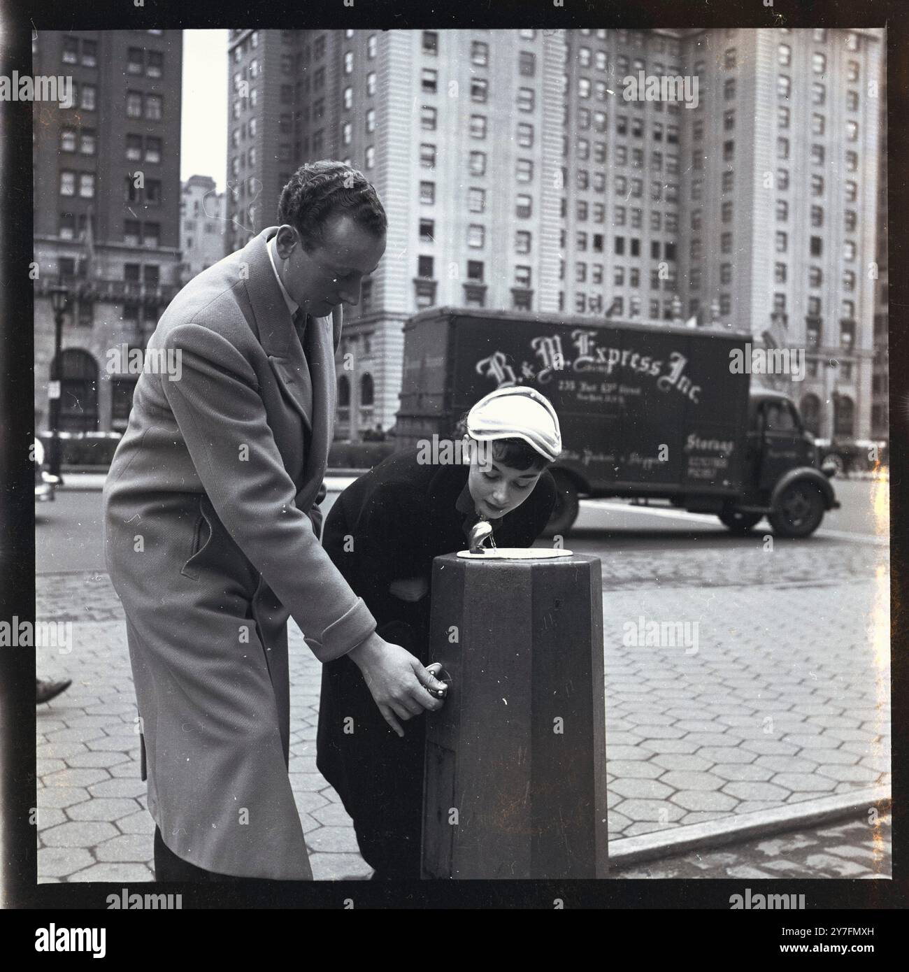 Audrey Hepburn benutzte einen öffentlichen Trinkbrunnen bei einem Besuch in New York, USA, wo sie 1952 in Gigi am Broadway, New York 1952 spielte. Sie ist mit ihrem Verlobten, James Hanson, auf einer Straße in Downtown Manhattan. Foto von George Douglas Stockfoto