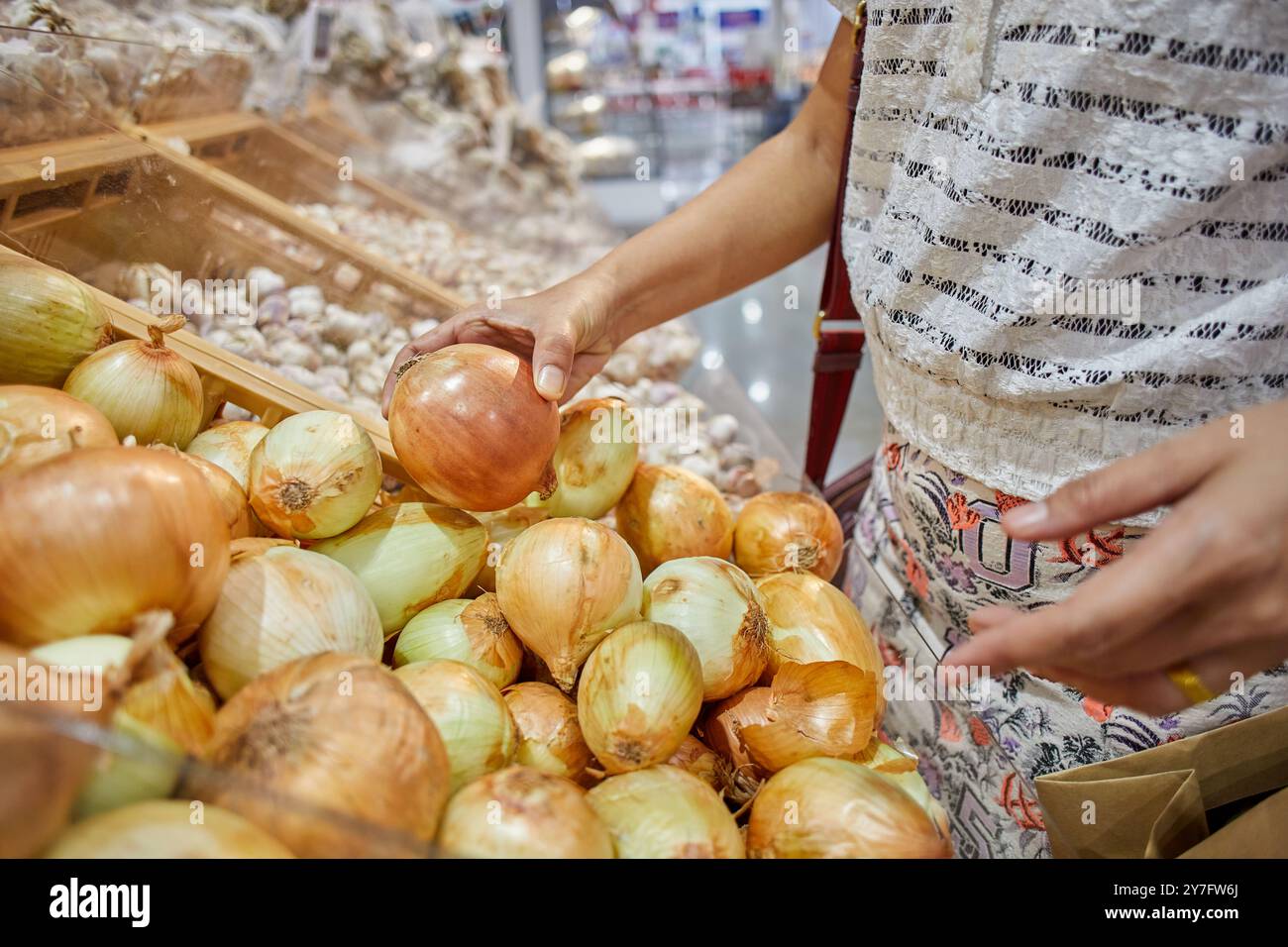 Nahaufnahme einer Frau, die im Supermarkt Zwiebeln ausgesucht hat Stockfoto