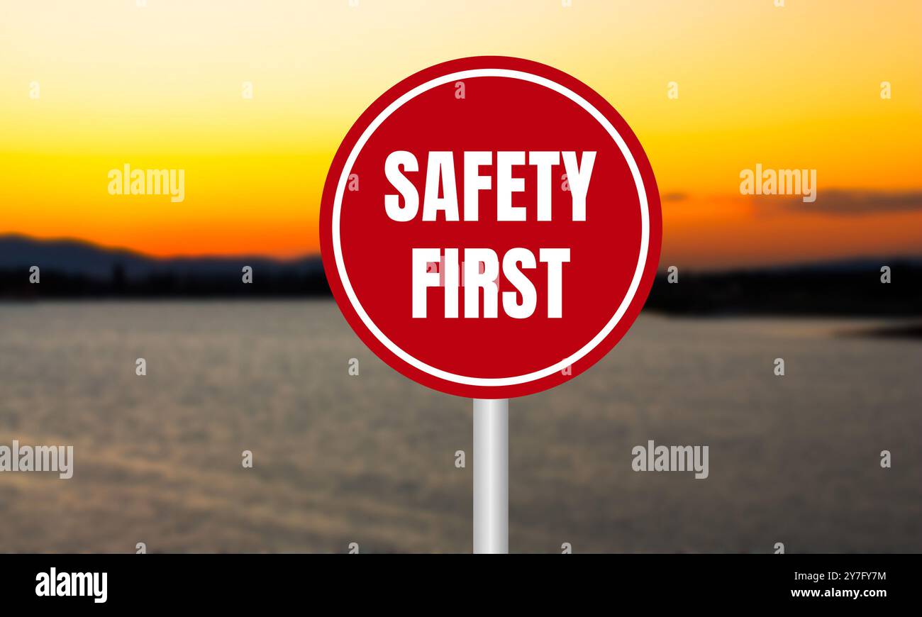 Sicherheitsmeldung auf rotem Schild auf unscharfem See-Hintergrund bei Sonnenuntergang. Symbol für konzeptionelle Sicherheit an erster Stelle. Kopierbereich. Stockfoto