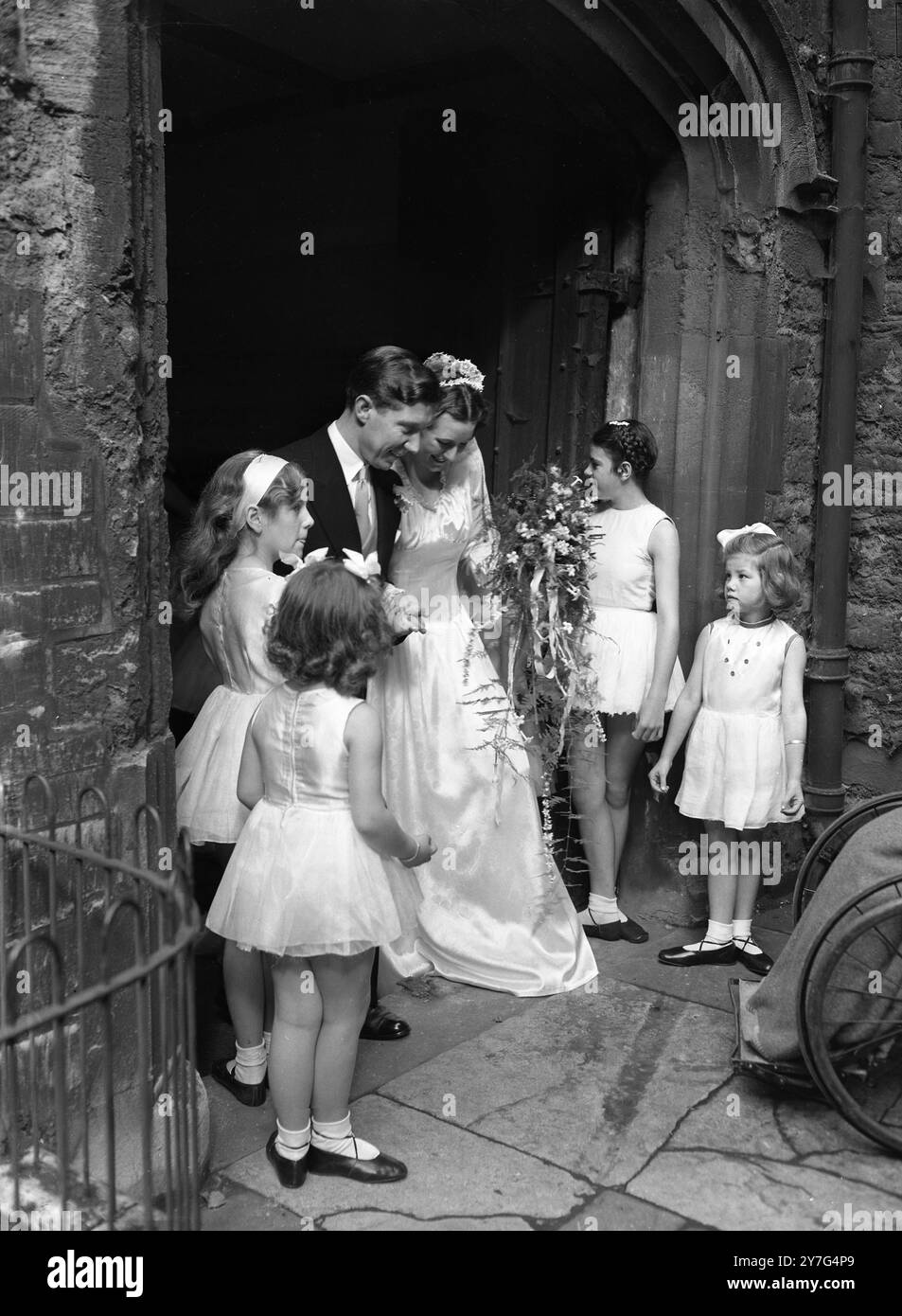 Die glückliche Braut und der Bräutigam verlassen die Kirche. Die Schüler der Ballettschule Maureens bilden eine Ehrengarde. September 1948 Stockfoto