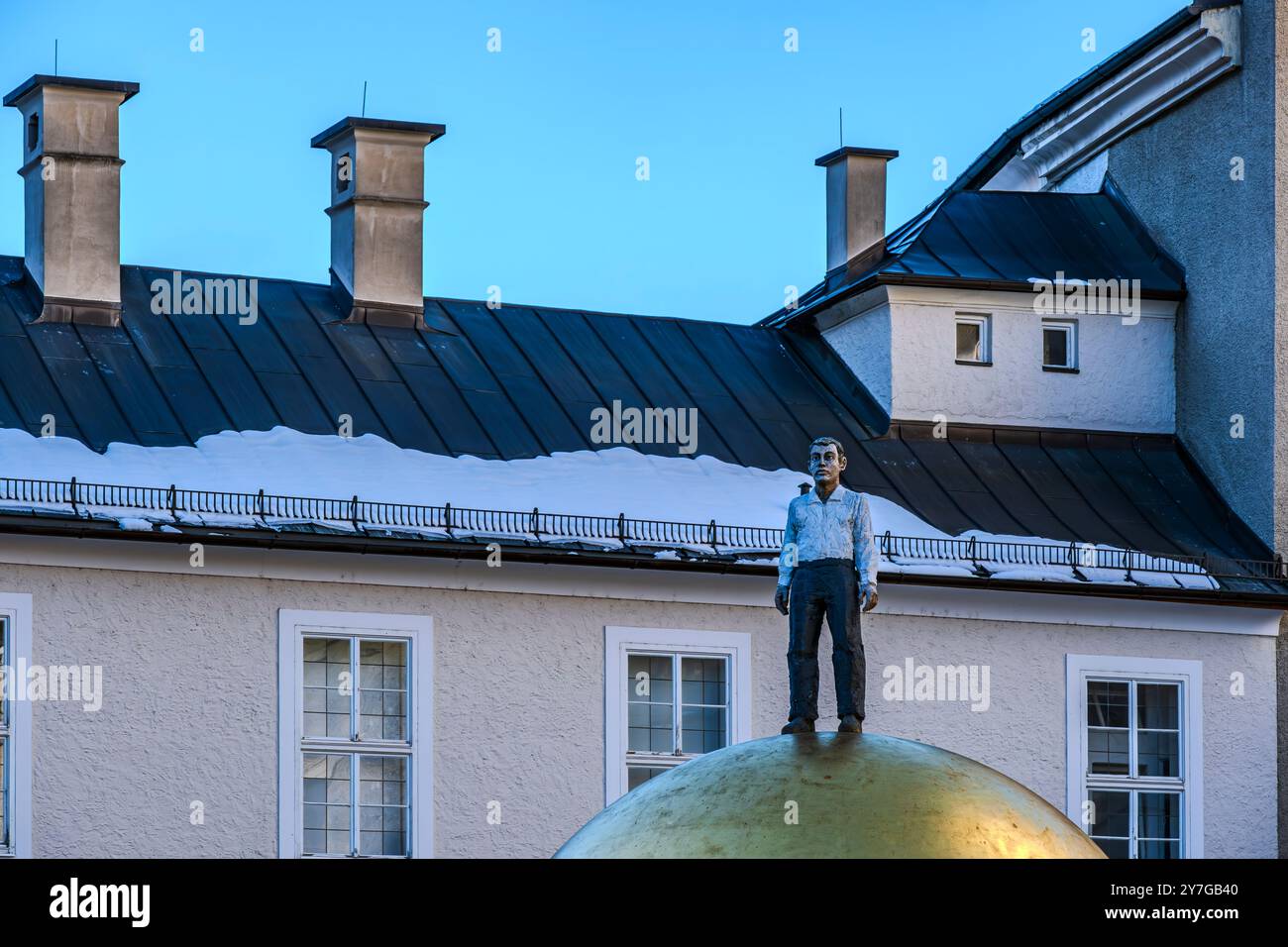 Das Kunstwerk „Goldene Kugel mit männlicher Figur“ von Stephan Balkenhol auf dem Kapitelplatz in der Altstadt von Salzburg, Österreich, nur für redaktionelle Zwecke. Stockfoto