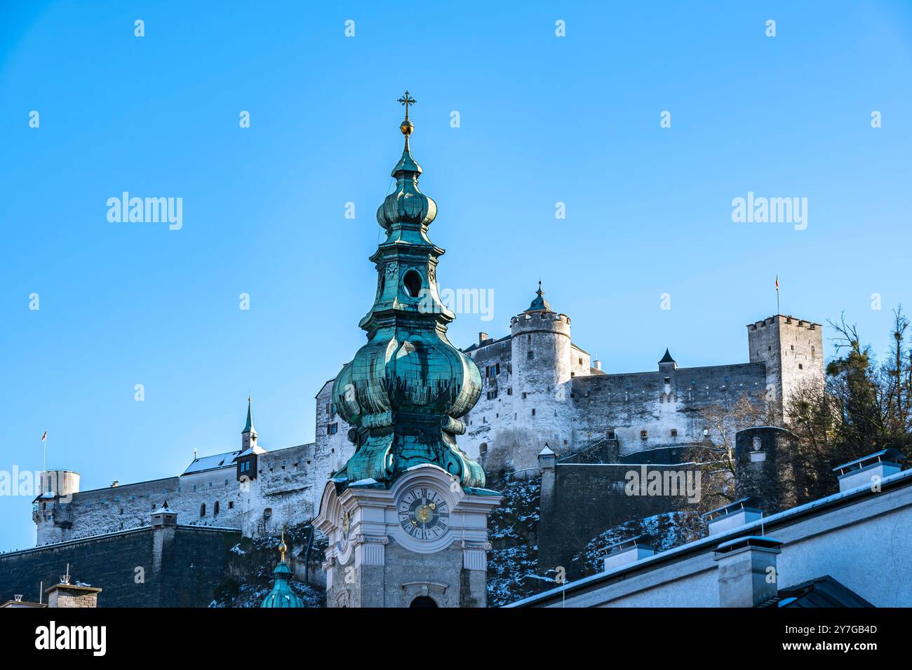 Turm der Stiftskirche St. Peter in der Altstadt von Salzburg, Österreich, mit Blick auf die Festung Hohensalzburg. Stockfoto