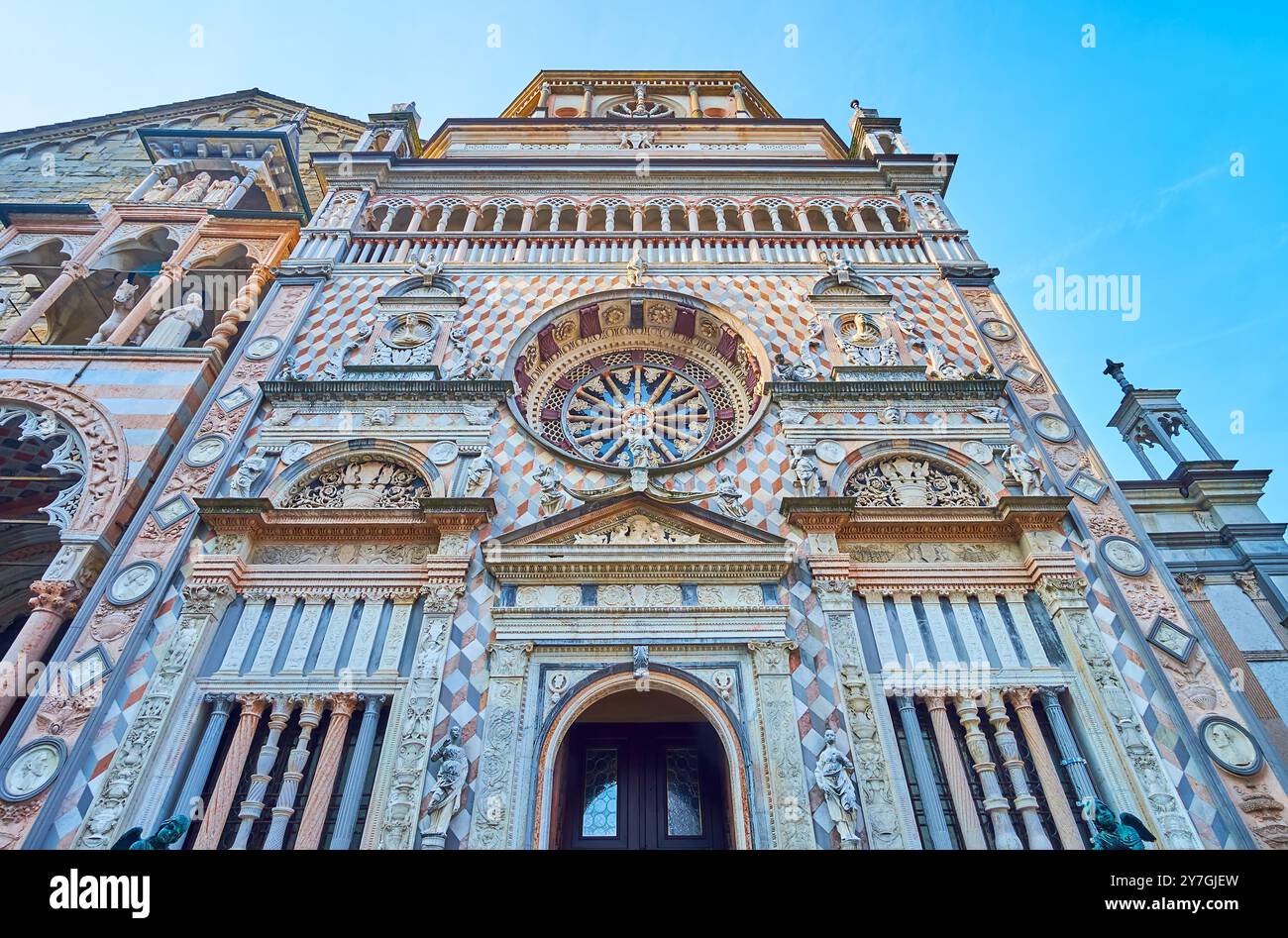 Die kunstvoll verzierte Fassade der mittelalterlichen Colleoni-Kapelle mit komplizierten Steineinlegemustern und Säulen verschiedener Formen, Bergamo, Italien Stockfoto