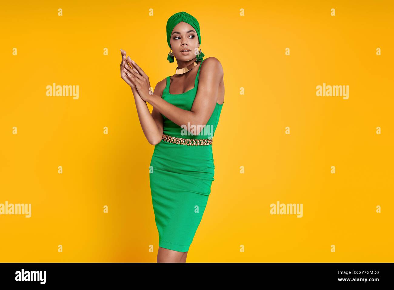 Schöne afrikanische Frau in traditioneller Kopfbedeckung, die auf gelbem Hintergrund steht Stockfoto