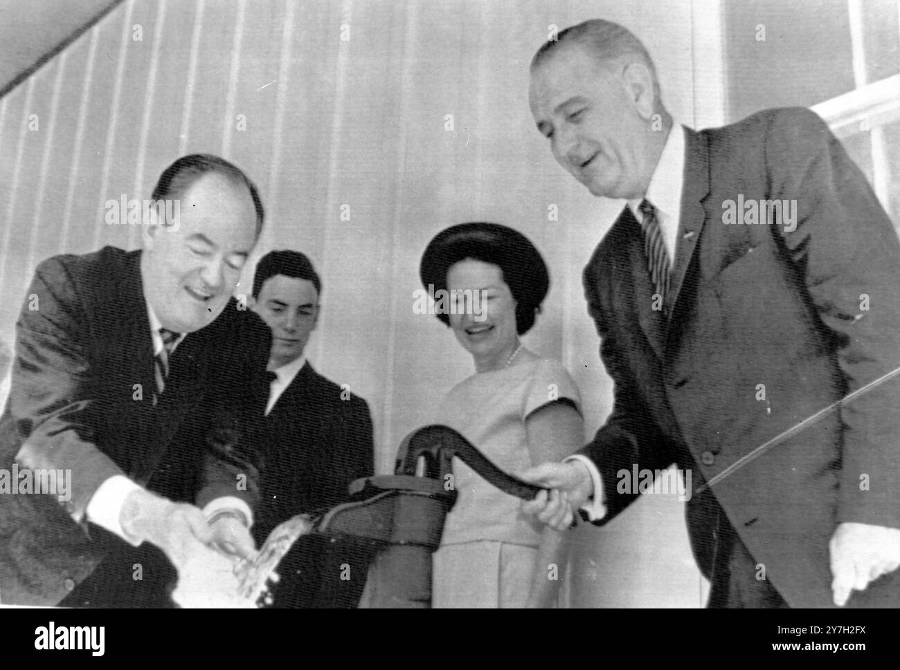 US-AMERIKANISCHER PRÄSIDENT LYNDON B JOHNSON PUMPT WASSER MIT SENATOR HUMPHREY UND SEINER FRAU IN JOHNSON CITY, TEXAS / ; 31. AUGUST 1964 Stockfoto