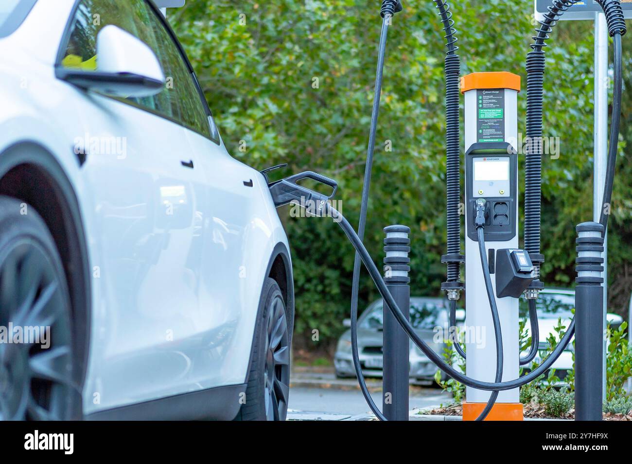 Nahaufnahme eines weißen Elektroautos, das an einer öffentlichen CHAdeMO EV-Ladestation in einem britischen Supermarkt in Sainsbury aufgeladen wird. Stockfoto