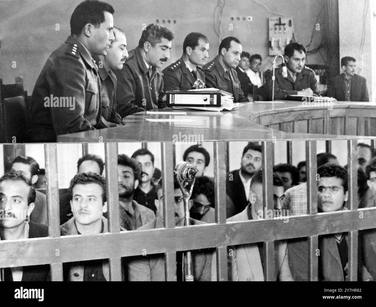 1. MAI 1964 neun im Aleppo-Prozess zum Tode verurteilt. Die beiden Seiten eines Prozesses. Im oberen Bild hörten die Richter eines Militärgerichts hier, am 30. April, Beweise an, während im unteren Bild die Angeklagten während des Verfahrens in einem Gerichtssaal untergebracht sind. Die Männer wurden vor Gericht gestellt, weil sie letzten Monat einen Polizeiposten angegriffen und Waffengeschäfte überfallen haben. Neun der Häftlinge wurden zum Tode verurteilt, und die übrigen mit einer Ausnahme wurden zu Haftstrafen von zwei Jahren bis zu lebenslänglich verurteilt. Ein Mann wurde freigesprochen. Drei der zu Gefängnisstrafen verurteilten Männer waren nicht vor Gericht, an Stockfoto
