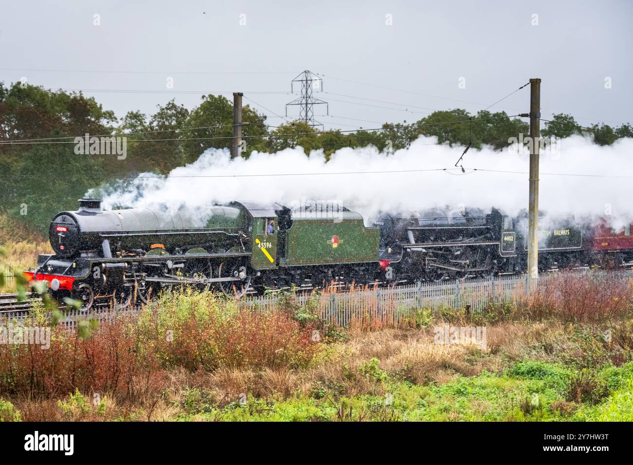 Dampflokomotiven Bahamas und Stanier Black Five Nummer 44392. Fahren Sie bei starkem Regen auf der West Coast Main Line in Winwick nach Norden. Stockfoto