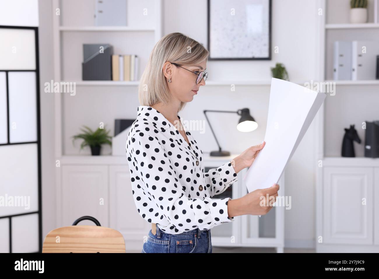 Architekt hält Papierbogen mit Konstruktionszeichnung im Büro Stockfoto