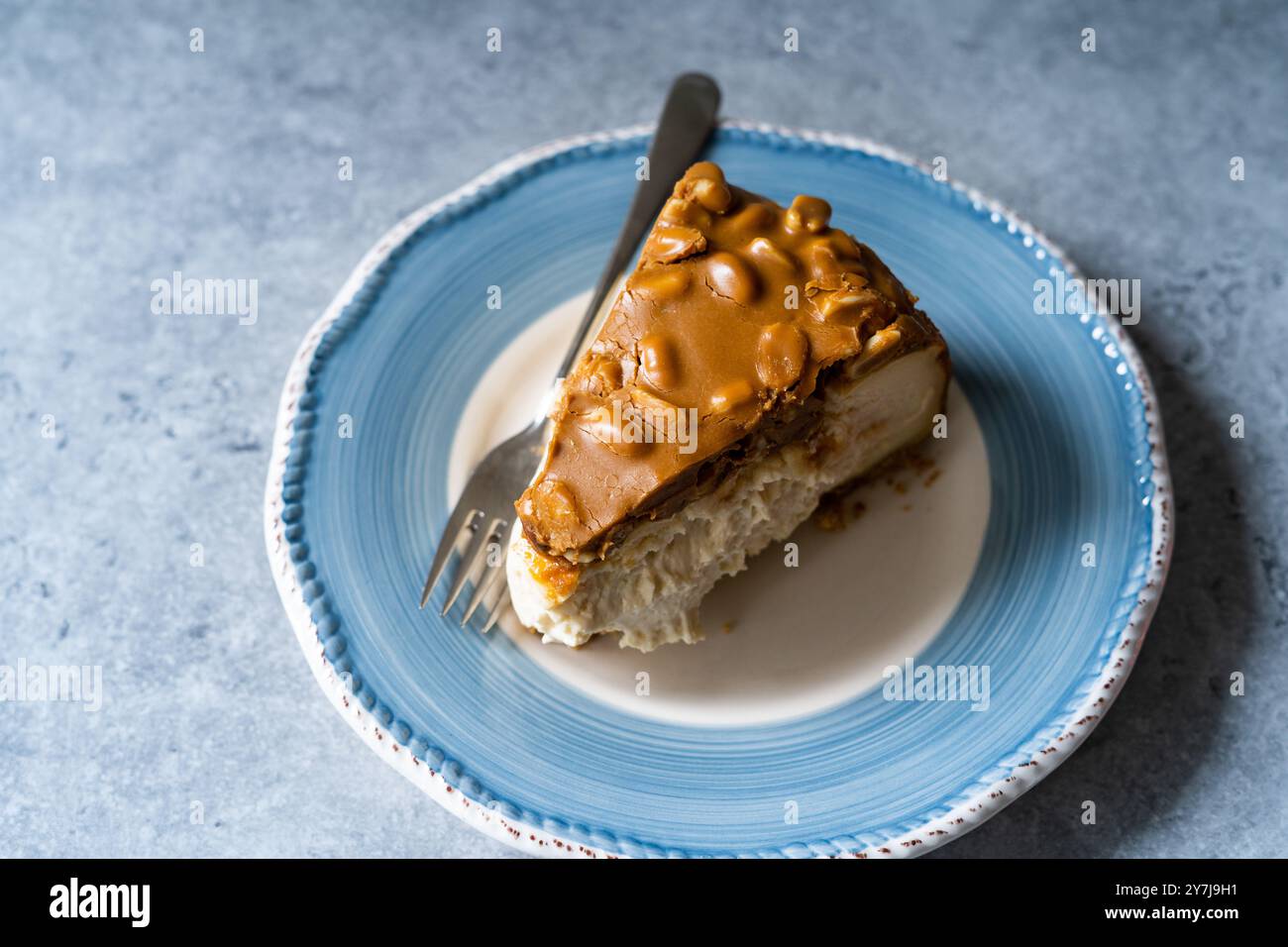 Hausgemachter Karamell-Erdnuss-Käsekuchen auf hellem Hintergrund. Bereit zum Essen. Stockfoto