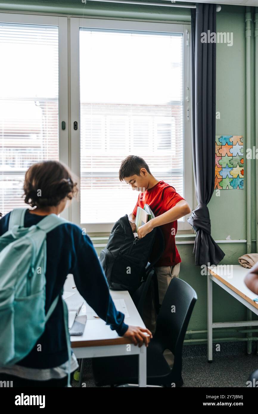 Seitenansicht des Rucksacks für Jungen, während er in der Schule steht Stockfoto