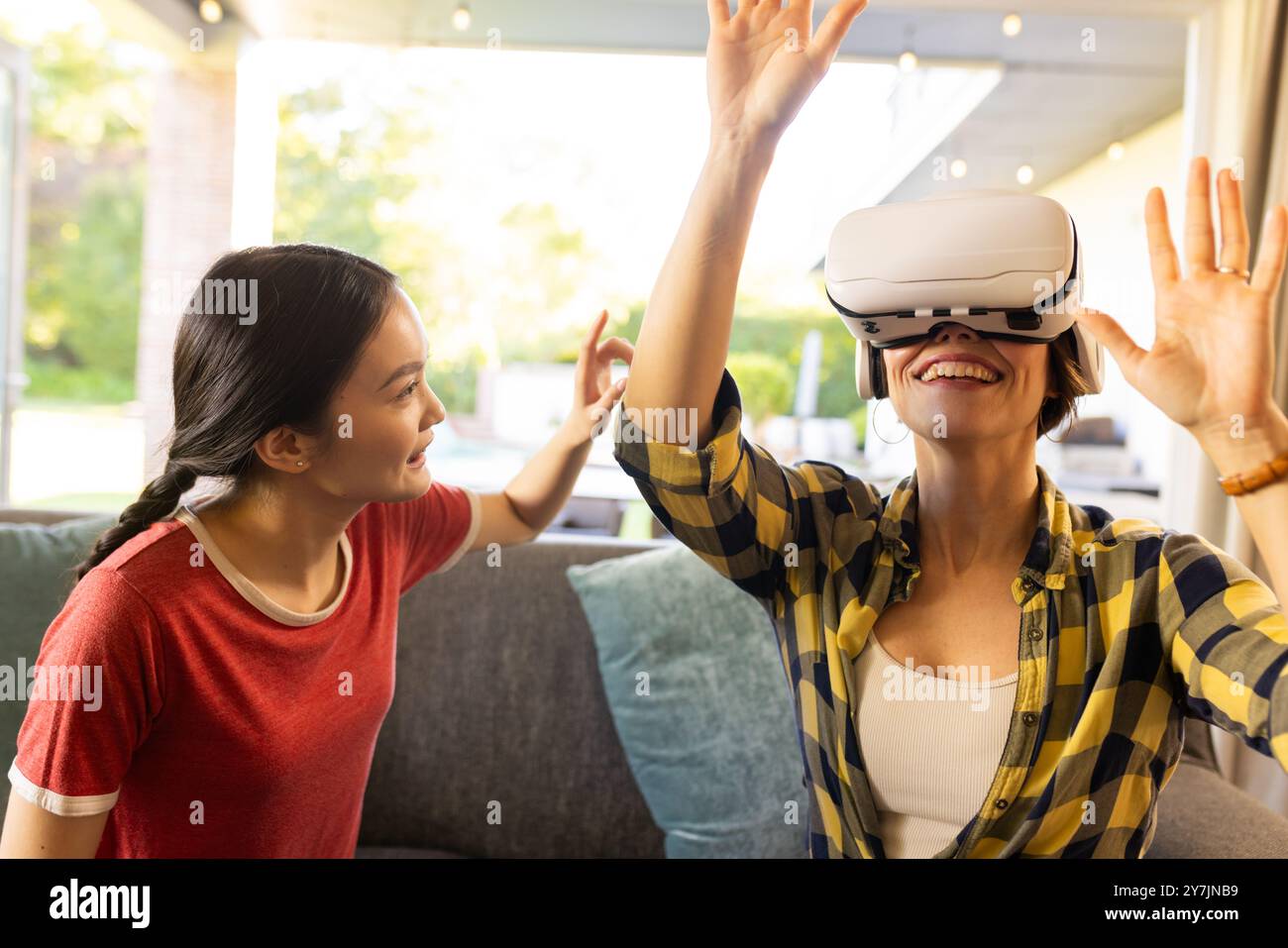 Mit dem VR-Headset genießt die Mutter das Virtual-Reality-Erlebnis mit der Tochter Stockfoto