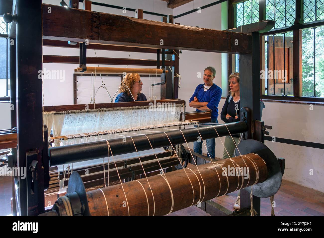 Besucher sehen eine Webvorführung auf alten Holztrappen im Freilichtmuseum Bokrijk, Limburg, Flandern, Belgien Stockfoto