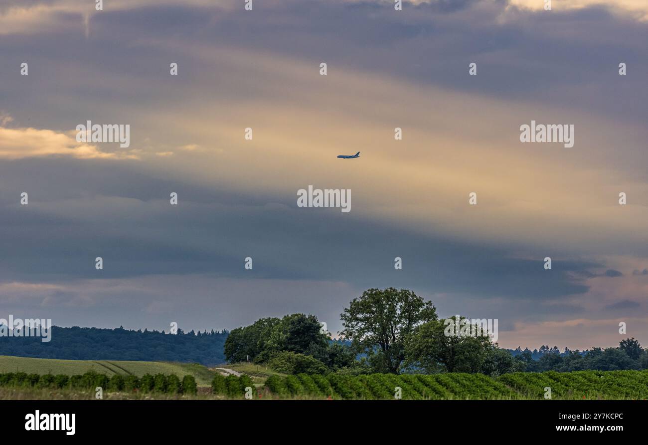 Oberglatt, Schweiz, 14. Juni 2024: Am Flughafen Zürich landet ein Flugzeug. Umgeben von dicken, grauen Wolken. Die Sonne findet ihren Weg durch den Clo Stockfoto