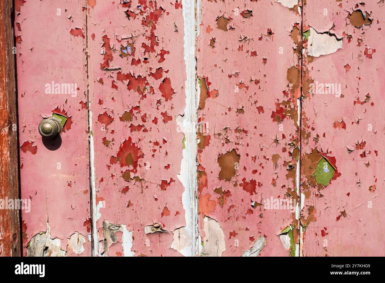 Abblätternde Farbe von überwiegend Rot und Grün eines Tores. Stockfoto