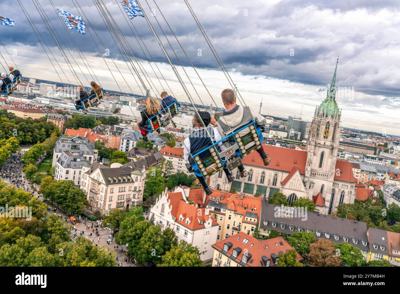 Wiesnbesucher genießen den Flug durch den Münchner Himmel, mit dem Kettenflieger Bayern Tower drehen sie sich in 90 Metern Höhe, Oktoberfest, München, September 2024 Deutschland, München, 30. September 2024, Wiesnbesucher genießt den Flug durch den Münchner Himmel, in 90 Metern Höhe haben sie einen wunderbaren Blick über die Stadt, vor ihnen liegt der Stadtteil Ludwigsvorstadt mit der Kirche St. Paul, der Kirchturm von St. Paul ist 97 Meter hoch, Kettenflieger Bayern Tower, 90 Meter hohes Kettenkarussell, Theresienwiese, Fahrgeschäft gehört Schausteller Egon Kaiser, Montagnachmittag, Himmel b Stockfoto