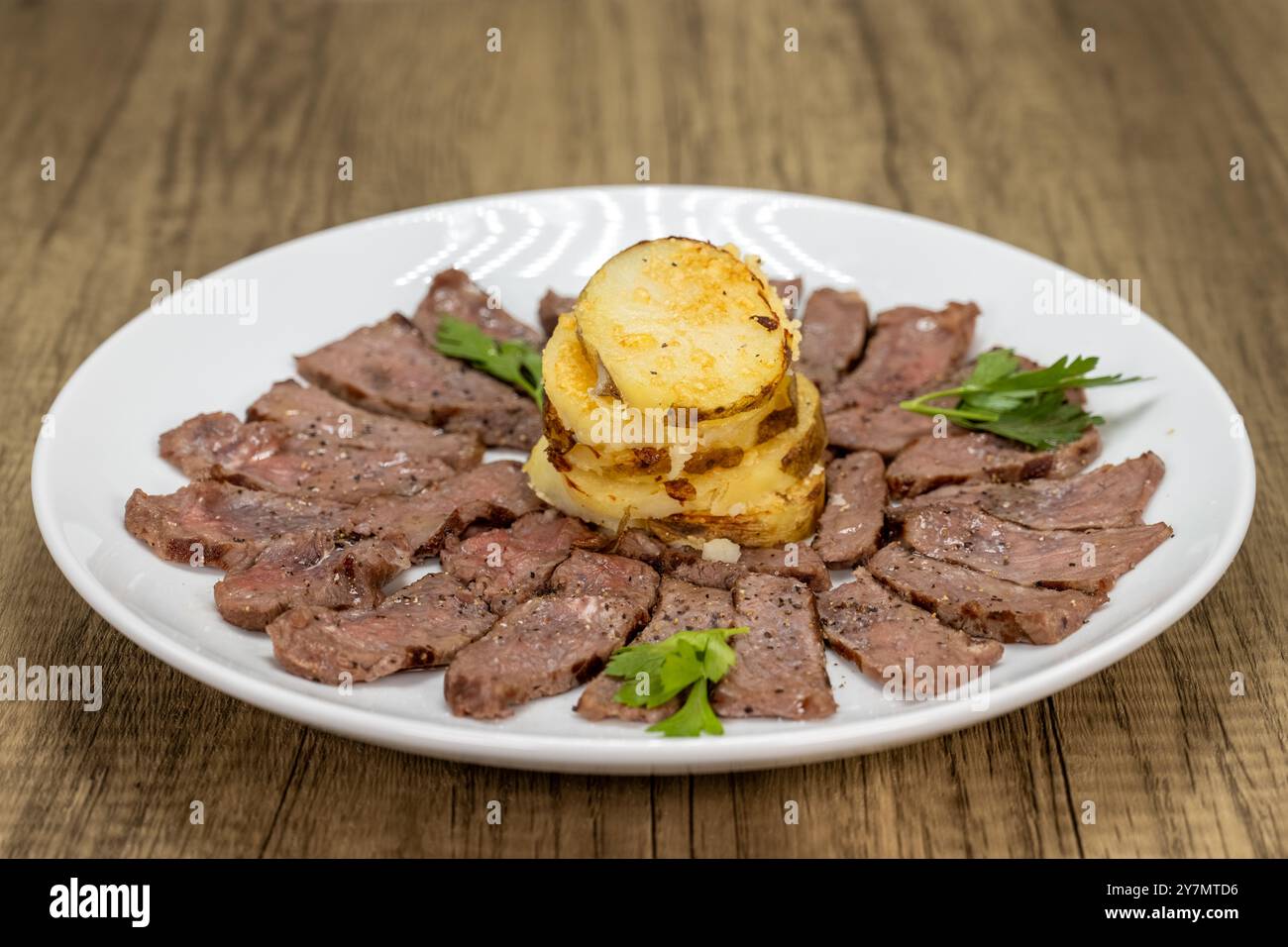 Fein geschnittenes New Yorker Steak, perfekt gekocht, serviert mit einem Stapel Kartoffelpüree. Stockfoto