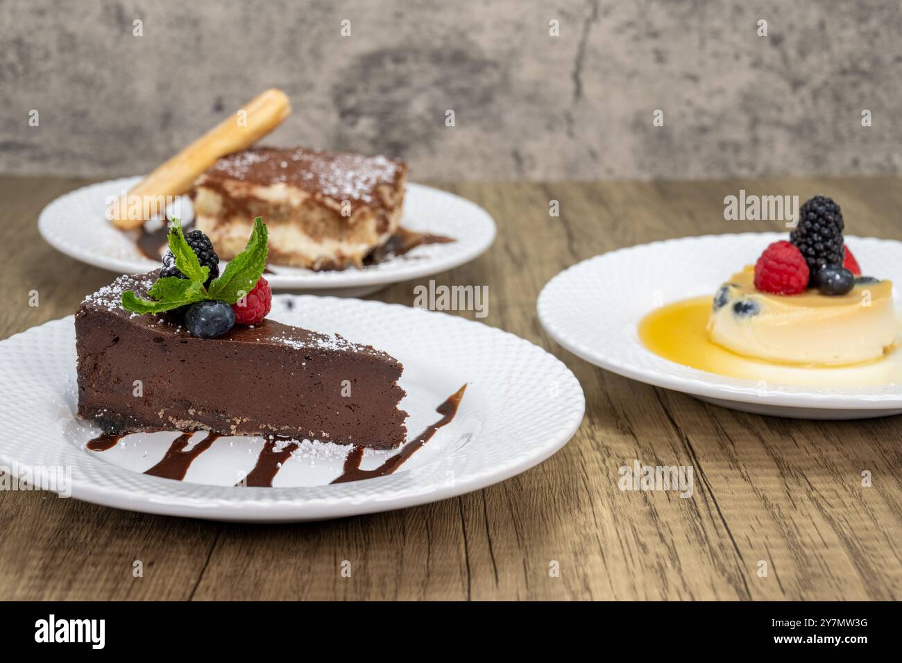 Italienisches Dessertmenü mit bitterem, süßem Schokoladenkuchen, Tirimasu oder Panna Cotta. Stockfoto