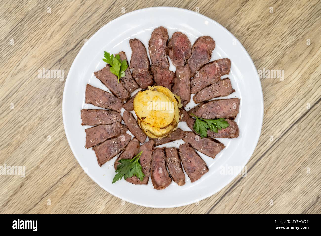 Blick von oben auf das dünne New Yorker Steak, das perfekt zubereitet und mit einem Stapel Kartoffelpüree serviert wird. Stockfoto