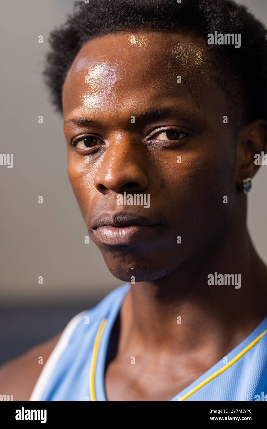 Nahaufnahme eines afroamerikanischen Basketballspielers im Trikot, der entschlossen und konzentriert aussieht Stockfoto