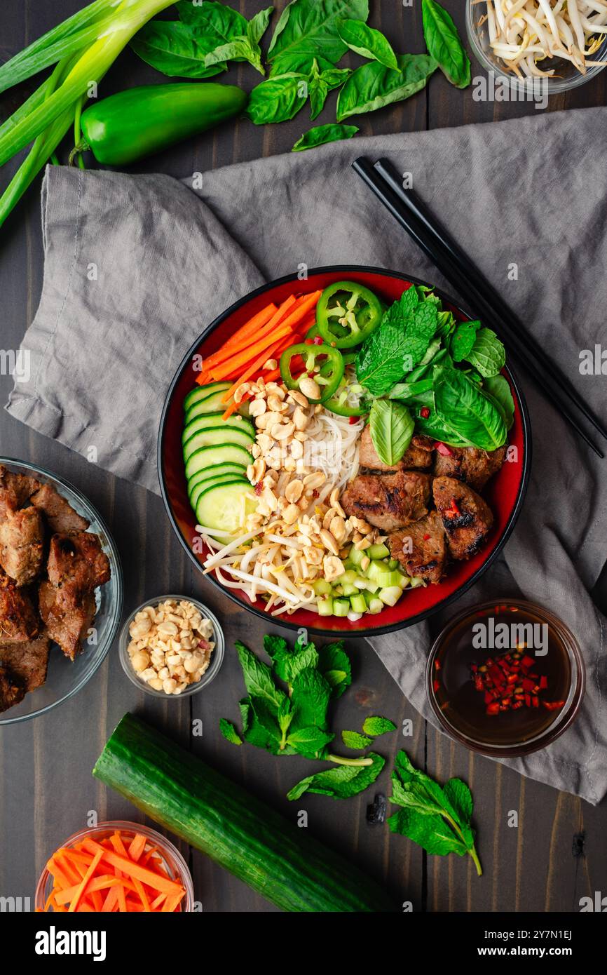 Brötchen Thit Nuong vietnamesisches gegrilltes Schweinefleisch mit Nuoc Cham: Schweinefleisch über Vermicelli-Nudeln mit frischen Kräutern, Erdnüssen, Gurken und eingelegten Karotten Stockfoto