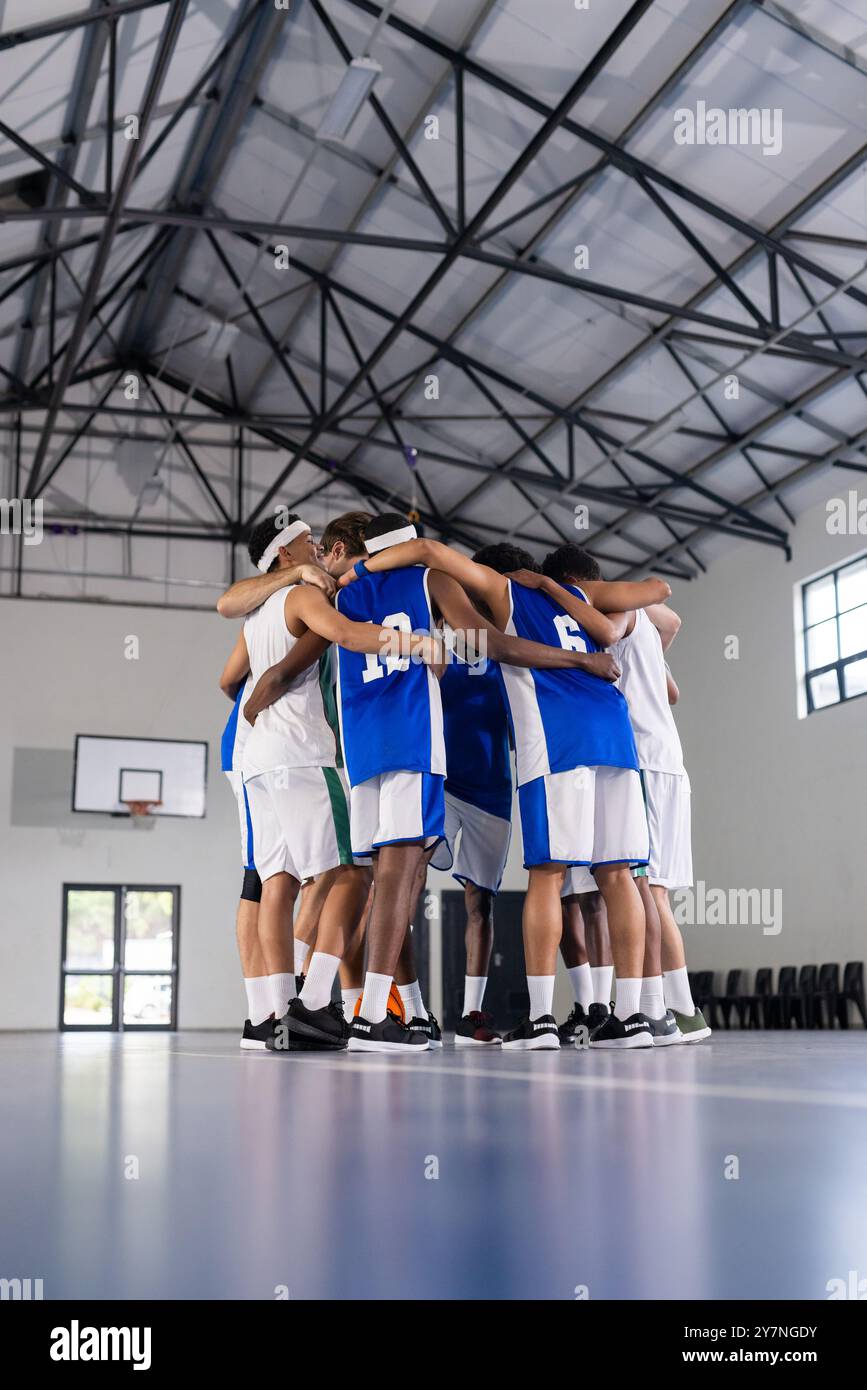 Basketballteam dröhnt sich auf dem Platz und bereitet sich auf das Spiel im Fitnessstudio vor Stockfoto