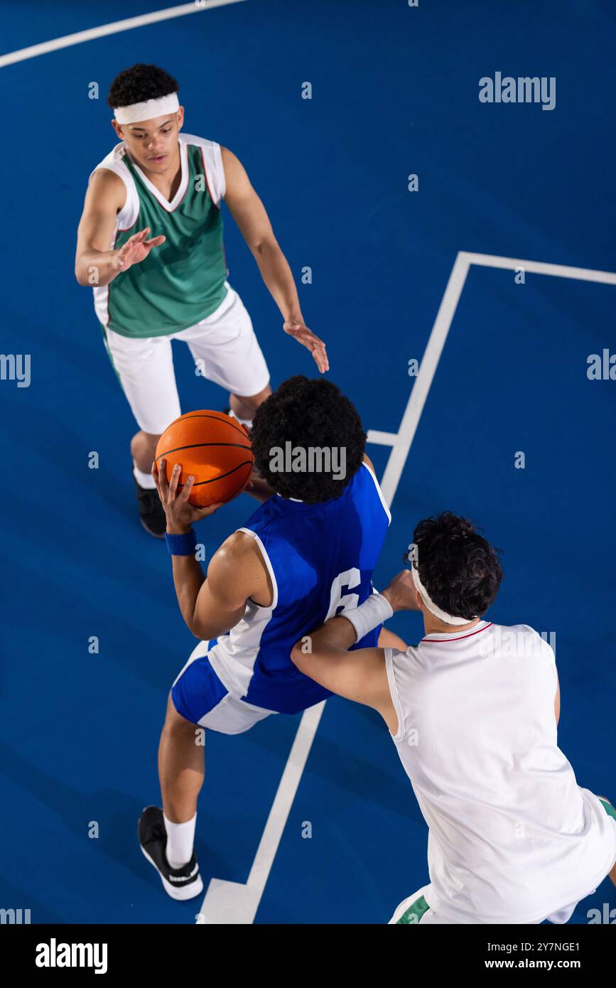 Spielen Basketball, drei Spieler in Aktion auf dem Platz während des Spiels Stockfoto