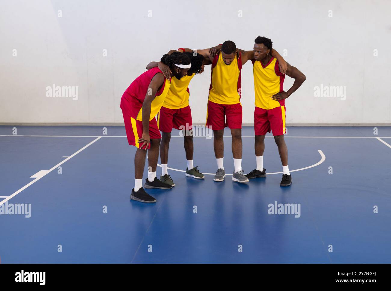 Afroamerikaner, die vor dem Spiel auf dem Hallenplatz strategisch arbeiten Stockfoto