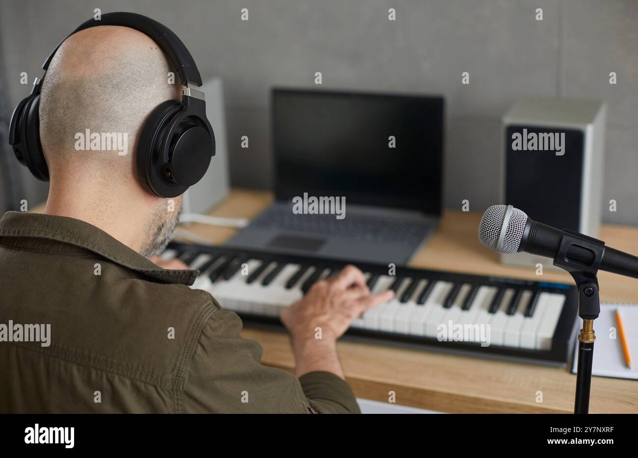 Der talentierte und inspirierte Mann konzentriert sich auf die Musik, während er auf der Tastatur des Synthesizers spielt. Stockfoto